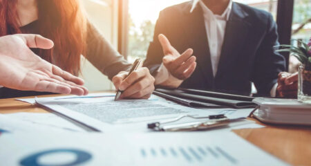 Two people working at a desk for an article on Real assets 