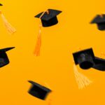 An orange background with multiple mortar board hats flyingthrogh thr air, for "What’s Your First Big Post-College Goal—and How Can You Fund It"